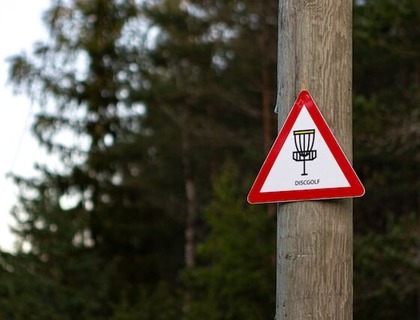A disc golf allowed sign in park.