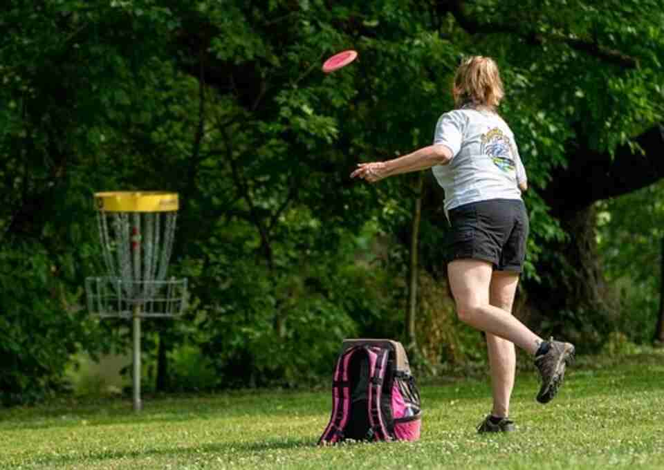 A woman playing disc golf.