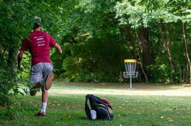 A man playing disc golf in a park.