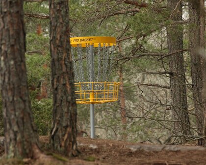 A yellow Disc Golf Basket Target