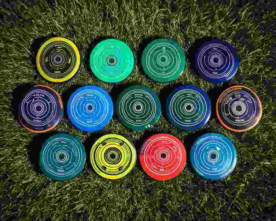 A collection of disc golf discs in various sizes, each one with distinctive features that set them apart from each other.